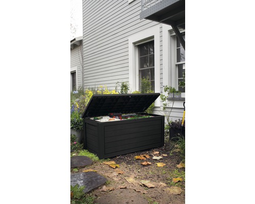 Otevřený černý zahradní box na trávníku před domem
