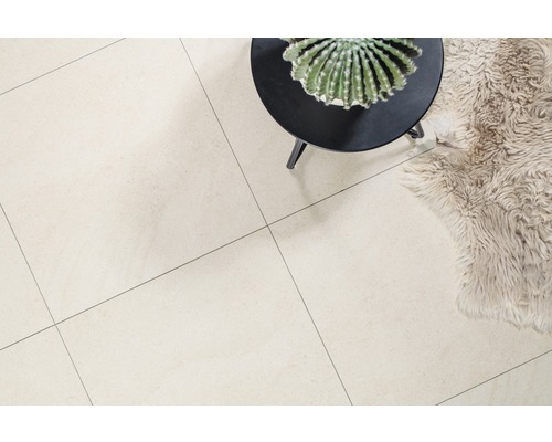 Světlá podlaha s dlaždicemi, malým stolem a dekorací