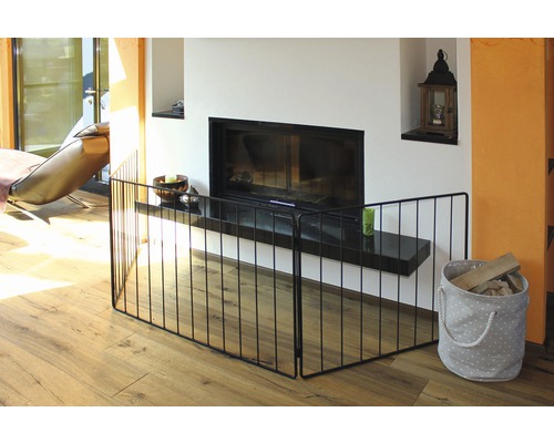 Obývací pokoj s kovovou ochranou krbu před krbem