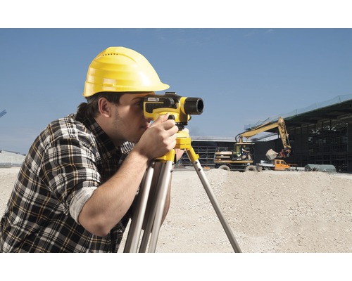 Stavební dělník s nivelačním přístrojem na staveništi