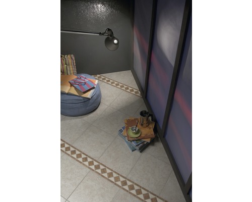 Pohled na pokoj s dlažbou, křeslem a lampou na čtení.