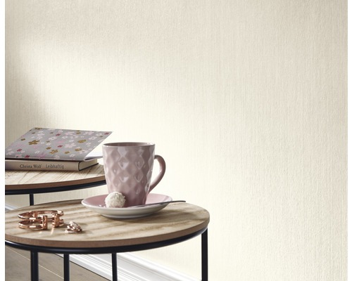 Detail béžové tapety v místnosti se stolem a dekorací.