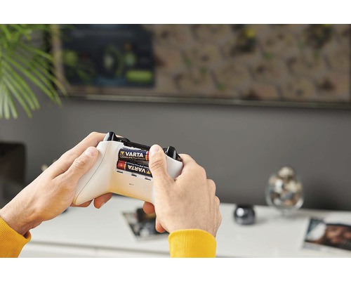 Osoba vkládá baterie Varta do ovladače Xbox.