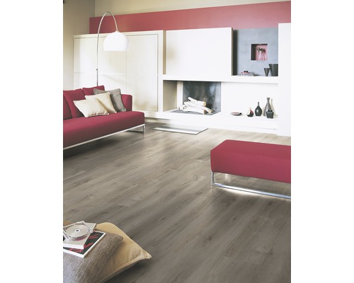 Světlý obývací pokoj s laminátovou podlahou, červenou pohovkou a krbem.