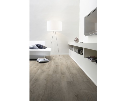 Světlý obývací pokoj s dřevěnou podlahou, pohovkou, stojací lampou a televizí