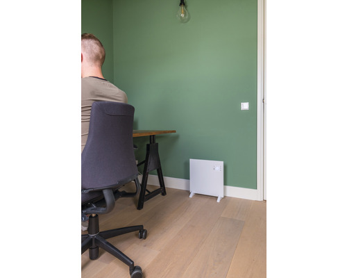 Kancelář se stolem, kancelářskou židlí a bílým topným tělesem