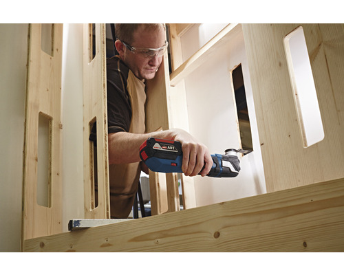 Muž pracuje s multifunkčním nástrojem na dřevěném rámu