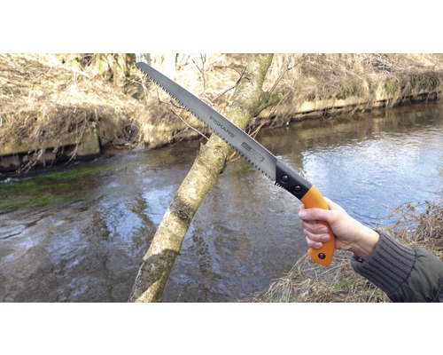 Ruční pila Fiskars řeže venku větev