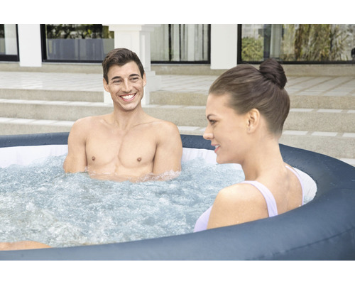 Dva lidé relaxují ve venkovní nafukovací vířivce.