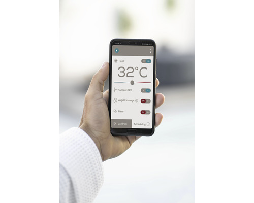 V ruce je držen smartphone s aplikací pro ovládání topení, masáže a funkcí filtru.