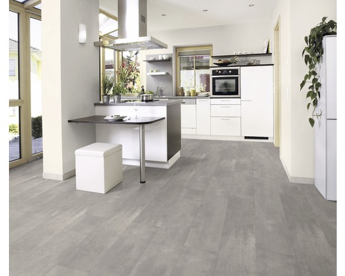 Světlá kuchyně s kuchyňskou linkou, jídelním stolem, sedací stoličkou a šedou podlahou