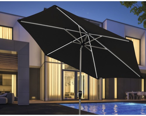 Obdélníkový slunečník s osvětlením před obytným domem