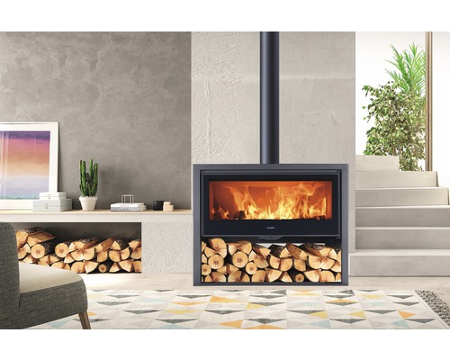 Krbová kamna s hořícím ohněm a dřevěnými poleny v obývacím pokoji