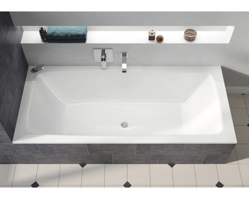 Obdélníková vana v koupelně s armaturami a odkládací plochou