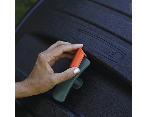 Detailní záběr ruky ovládající rukojeť kompostéru.