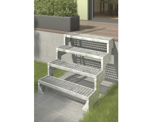 Venkovní schodiště se třemi stupni z kovových roštů před stěnou domu