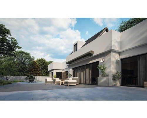 Venkovní pohled na moderní dům s markýzou, zahradním nábytkem a udržovanou zahradou