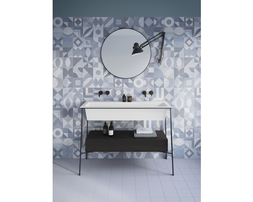 Koupelna s umyvadlem, zrcadlem, lampou a geometrickými obklady