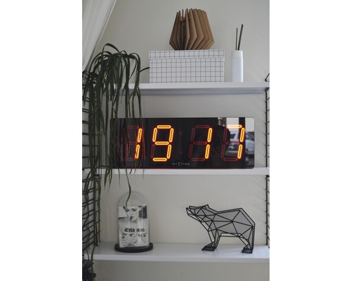 Police s digitálními hodinami, dekorací a rostlinou