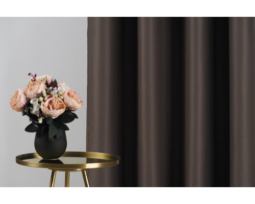 Dekorativní aranžmá s kyticí na stole před závěsem