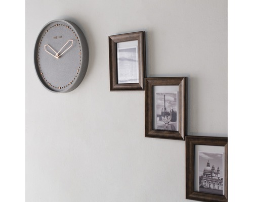 Nástěnné hodiny a tři fotorámečky na zdi