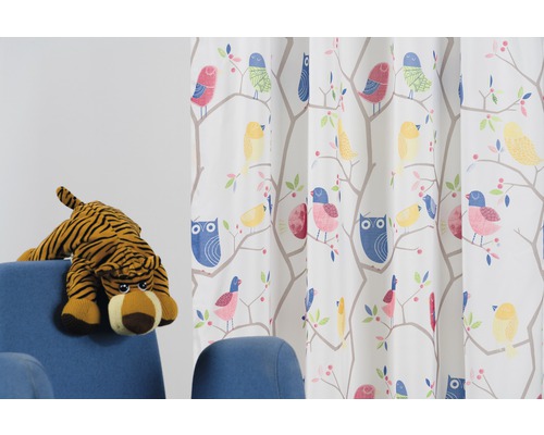 Závěs s designem ptáků a sov vedle modrého křesla s plyšovým tygrem