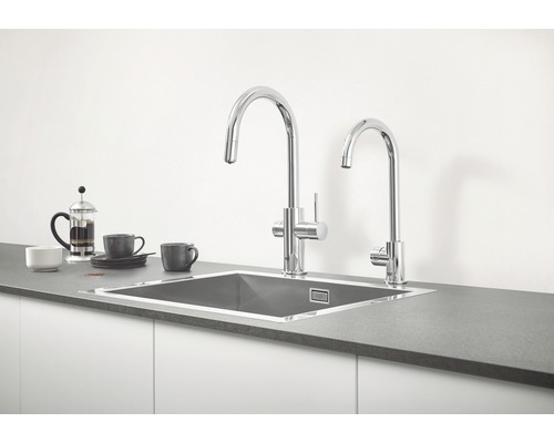 Dřez se dvěma vodovodními bateriemi na kuchyňské lince.