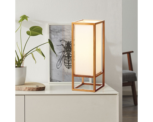 Stolní lampa s dřevěným rámem a stínidlem na stole