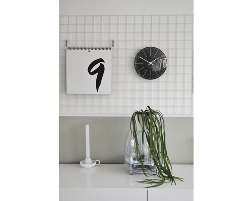 Dekorativní pokojové prostředí s kalendářem, hodinami a pokojovou rostlinou na skříňce