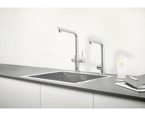 Kuchyňský dřez se dvěma vodovodními bateriemi a pracovními materiály na kuchyňské lince