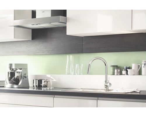 Kuchyňská scéna s kuchyňskou baterií, dřezem, varnou deskou, digestoří a kuchyňskými spotřebiči.