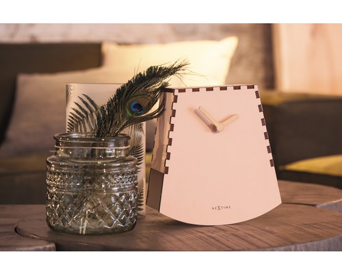 Dekorativní scéna se stolními hodinami, vázou a pavím pérem na stole