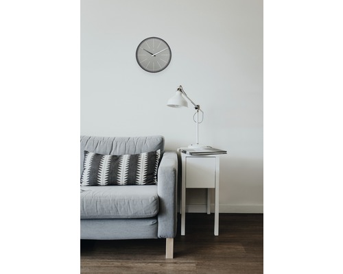 Obývací pokoj s pohovkou, polštářem, hodinami, lampou a nočním stolkem