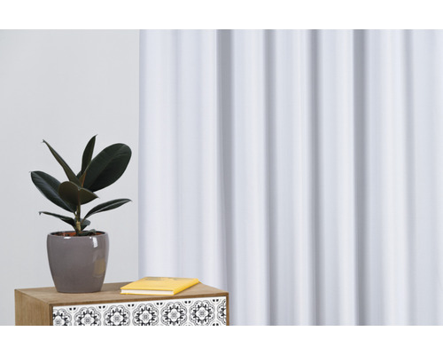 Interiérová scéna s pokojovou rostlinou, knihou a ozdobným závěsem