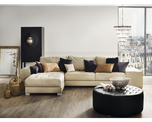 Obývací pokoj s rohovou sedačkou, konferenčním stolkem, skříní, stojací lampou a dekorací