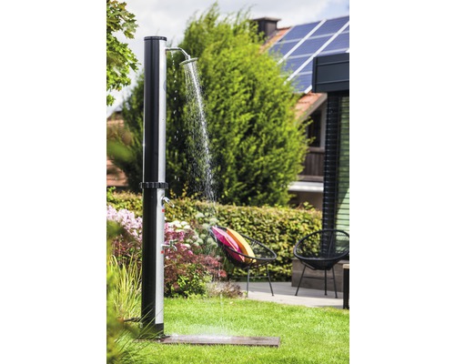 Zahradní scéna se stojací venkovní sprchou na trávníku