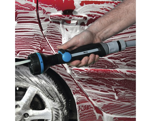 Osoba myje auto pomocí víceúčelové stříkací pistole.