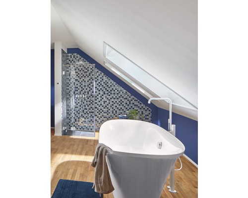 Koupelna s vanou, sprchou a střešním oknem v domě