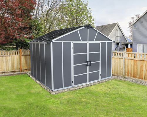 Šedý zahradní domek s dvoukřídlými dveřmi na zahradě