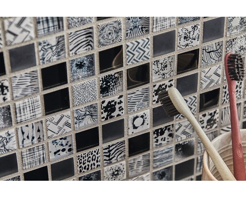 Detailní záběr mozaikových dlaždic s různými vzory a dvěma zubními kartáčky