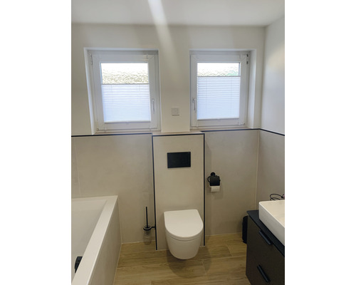 Světlá koupelna s toaletou, umyvadlem, vanou a dvěma okny s plisovanými žaluziemi