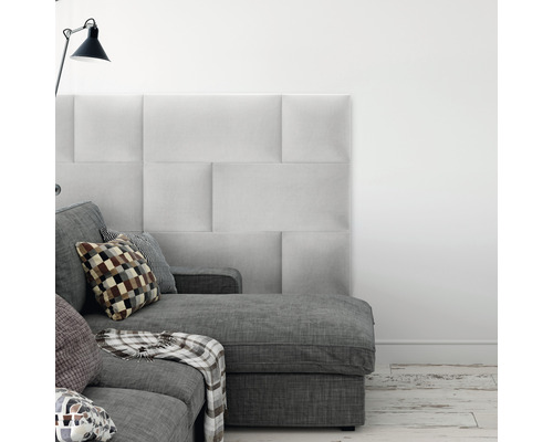 Čalouněný nástěnný panel Kingston 30x60 cm světle šedá Obývací pokoj s šedou pohovkou, polštáři a čalouněnými stěnovými panely pro stylový interiér.