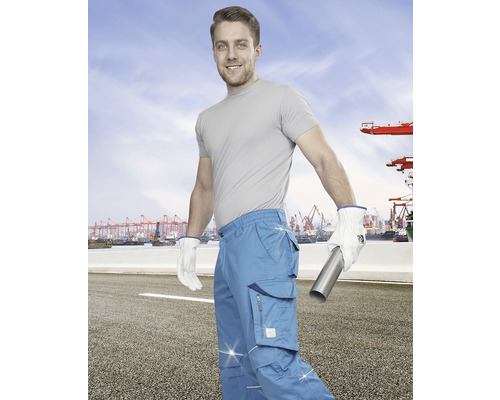 Muž s pracovními kalhotami, rukavicemi a kovovou trubkou před přístavem