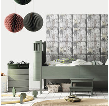 Dětský pokoj s postelí, hračkami a košem na prádlo.