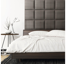 Ložnice s postelí, lampičkou a čalouněným čelem postele s kostkovaným vzorem