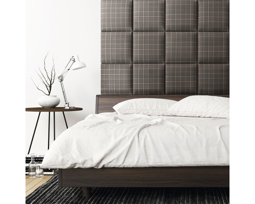 Ložnice s postelí, lampičkou a čalouněným čelem postele s kostkovaným vzorem