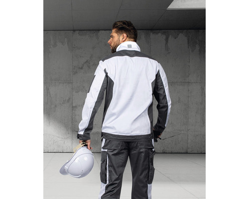 Muž zezadu v šedém a bílém pracovním oděvu s ochrannou přilbou