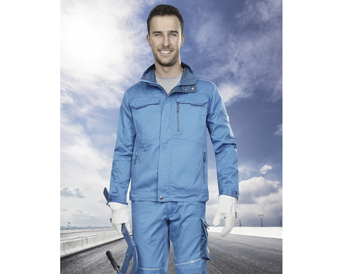 Muž má na sobě modré pracovní oblečení s bundou a kalhotami