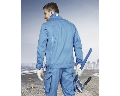 Muž má na sobě modré pracovní oblečení a drží nástroj