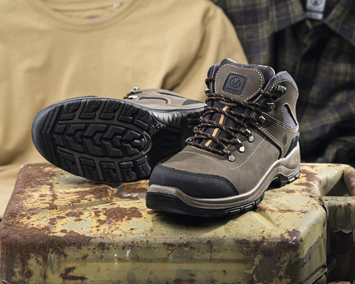 Hnědé pánské turistické boty na rezavém kovovém kanystru